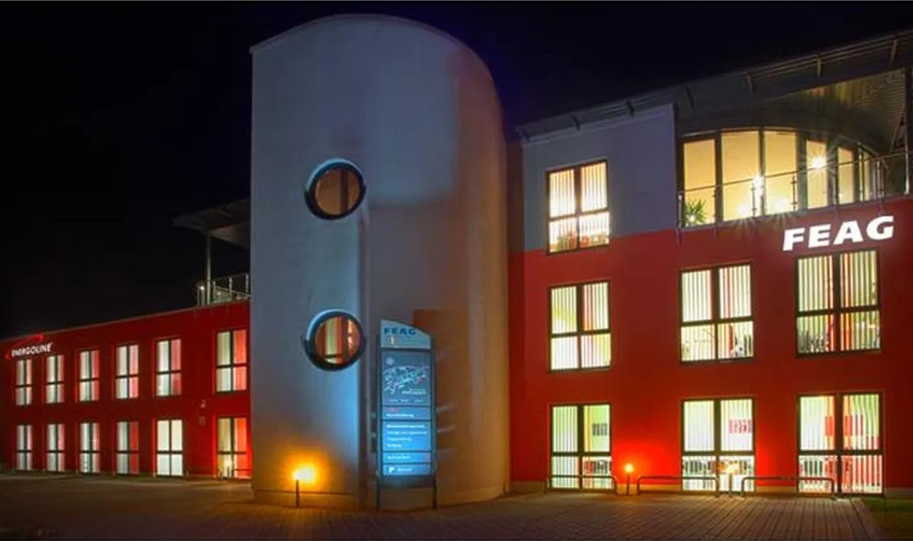 Beleuchtetes Gebäude des Unternehmens FEAG bei Nacht.