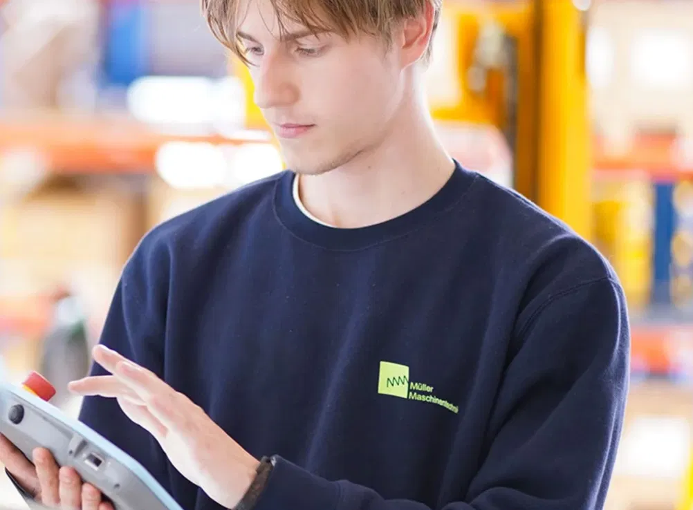 Mitarbeiter bedient ein digitales Tablet in der Produktion.